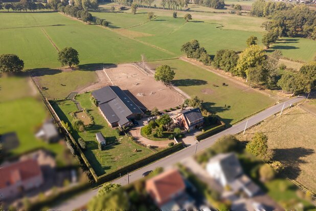 Woning met paardenstallen, piste en weiland op ca. 1,3 ha.