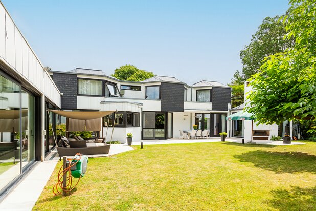 Topgelegen architectenwoning met ruim tuin en binnenzwembad.