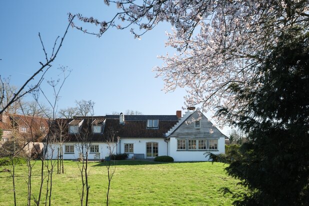 Karaktervolle hoeve met 5 slaapkamers en 4 badkamers, discreet gelegen op de tweede bouwlijn in een groene omgeving.